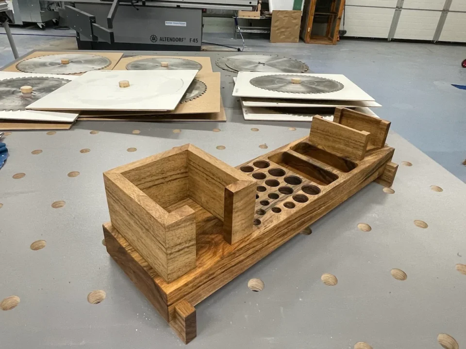 Ein Schreibtisch-Organizer aus Holz platziert auf einem Metallarbeitstisch in einer Werkstatt.